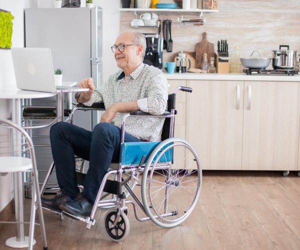 senior-man-wheelchair-using-laptop-kitchen-disabled-senior-man-wheelchair-having-video-conference-laptop-kitchen-paralyzed-old-man-his-wife-having-online-conference (1)